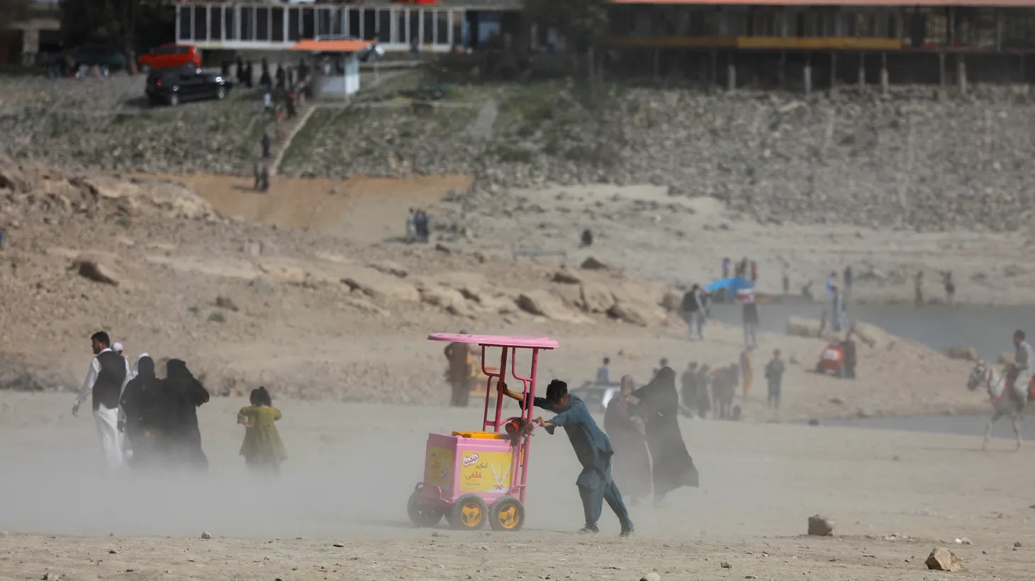 A person pushes a cart during a dust storm in Qargha lake in Kabul, Afghanistan, July 29, 2022.
