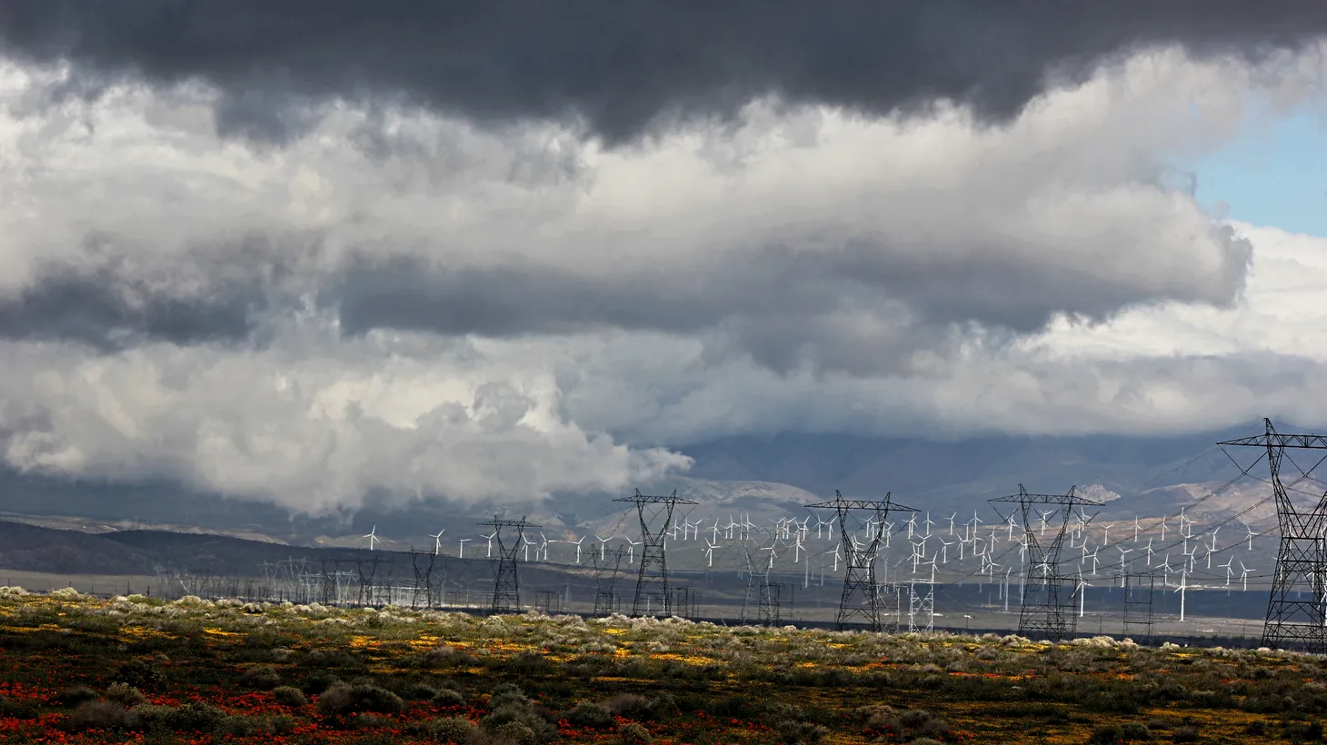 Electric power towers are seen beneath dense and gray clouds in Southern California.