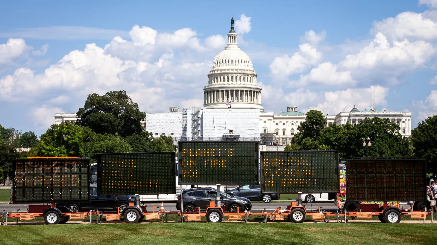 Road construction signs convey messages about climate change, as they’re parked in front of the U.S. Capitol ahead of the Senate's vote on the Inflation Reduction Act. The bill contains investments to address climate change, plus other tax, health care, and employment provisions.