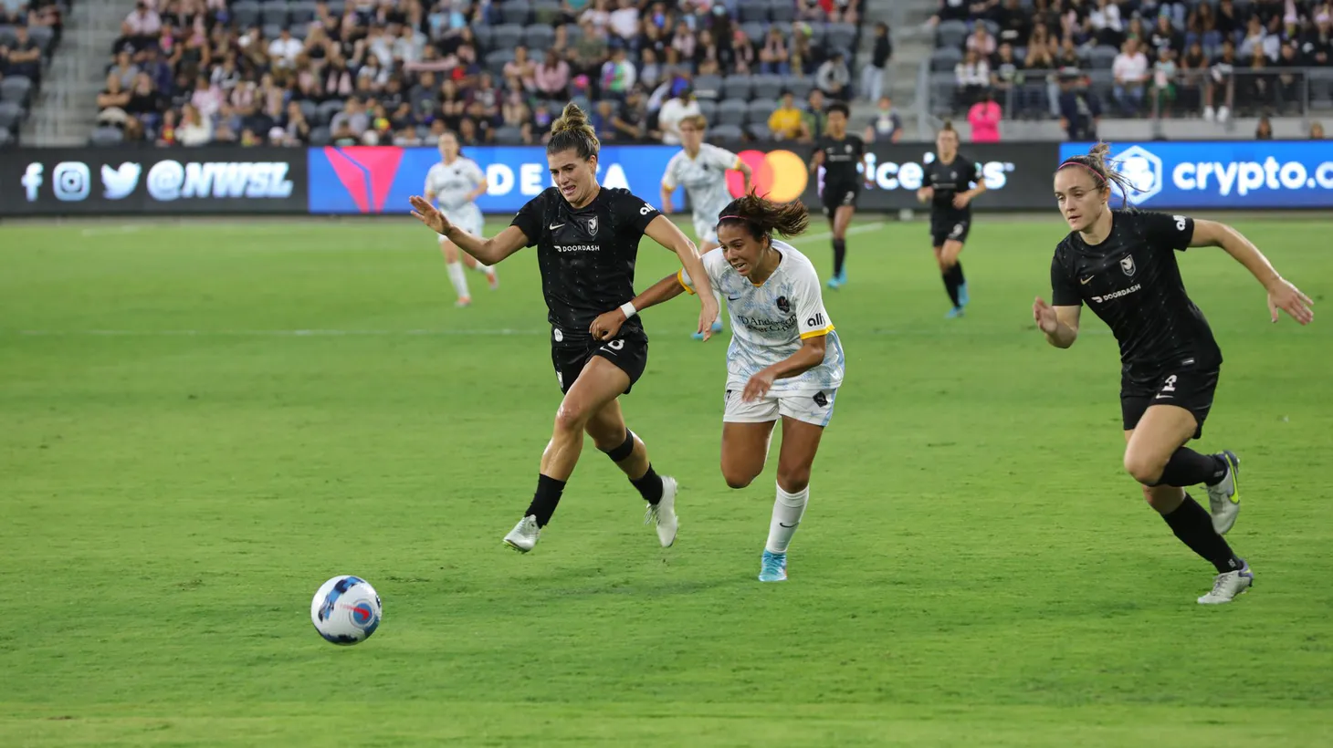 Players fight for the ball in a June 2022 game between Angel City FC and the Houston Dash.