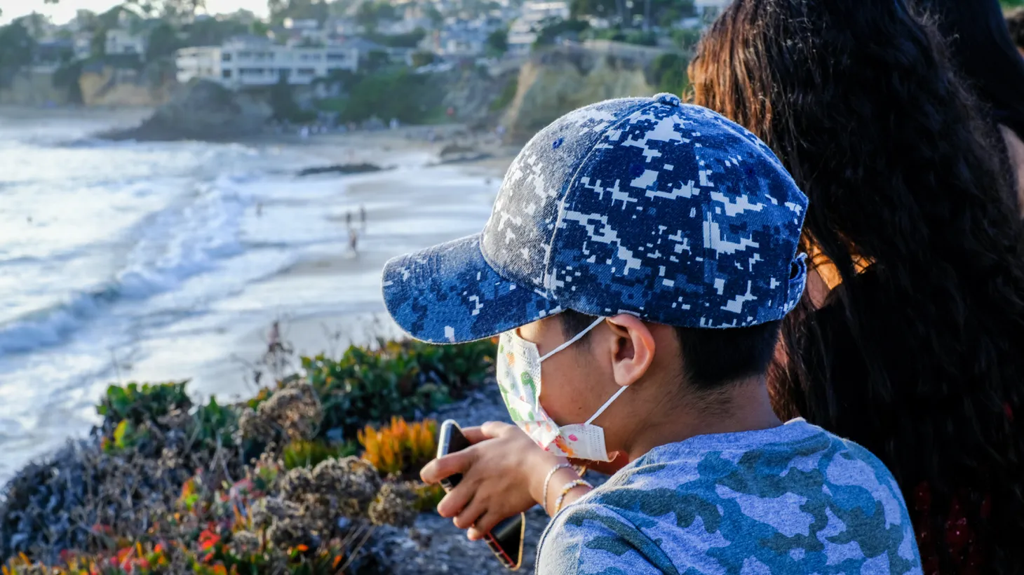 A boy wears a face mask outdoors in Laguna Beach, California.