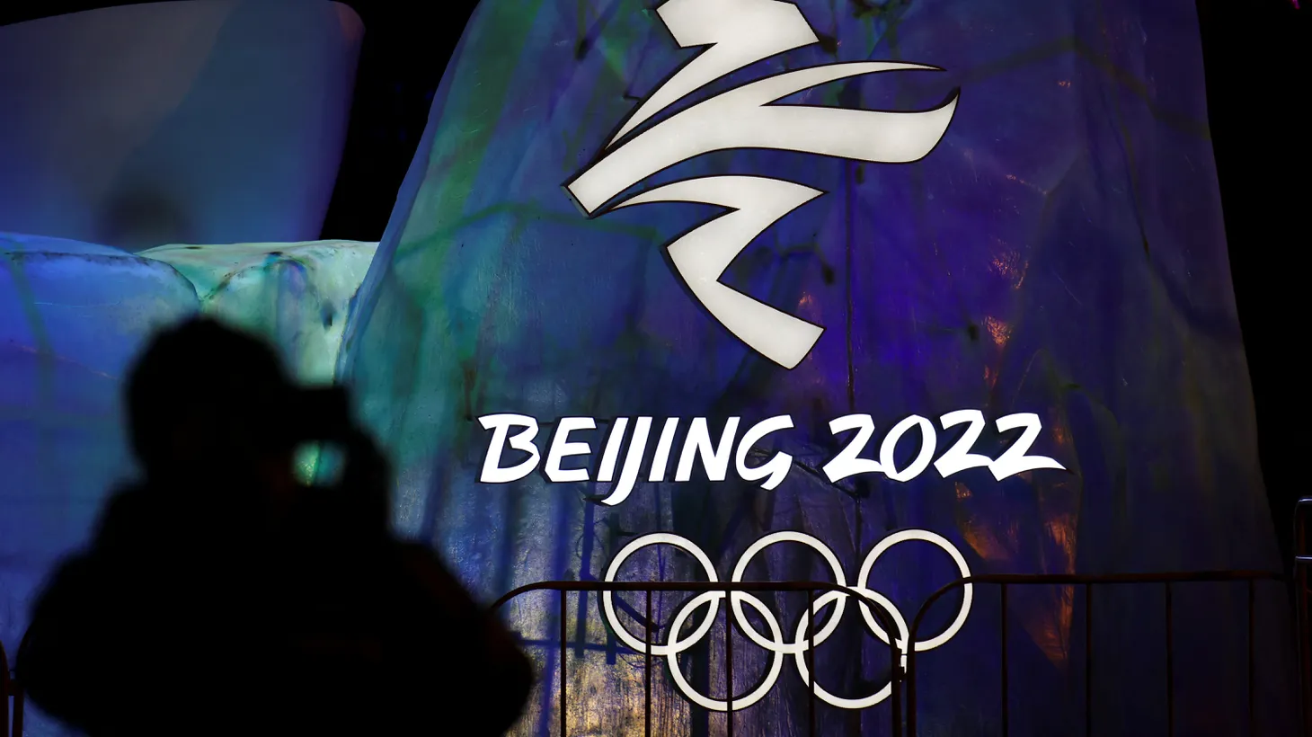 A man photographs an illuminated logo ahead of the 2022 Winter Olympics in Beijing, China, January 26, 2022.