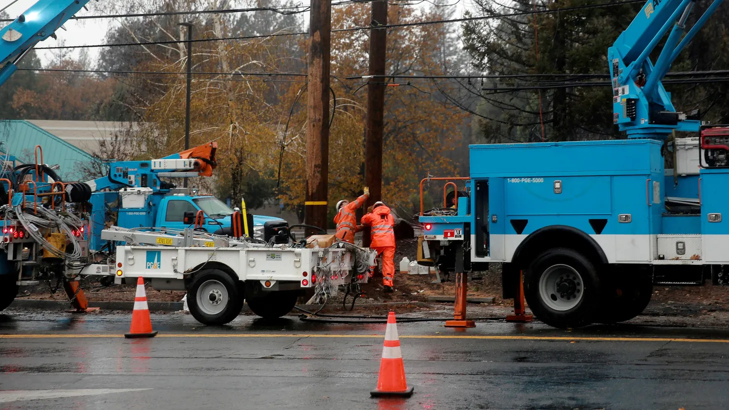 PG&E crew members work on power lines to repair damage caused by the Camp Fire in Paradise, California, November 21, 2018.
