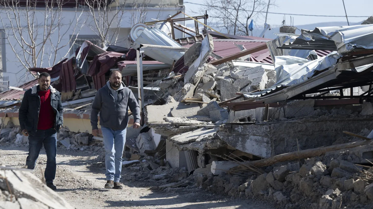 Two men walk along destroyed houses. In the small village, almost all the houses have collapsed or are badly damaged, and many people have died. A week after the earthquake in Turkey and Syria, the number of dead continues to rise.