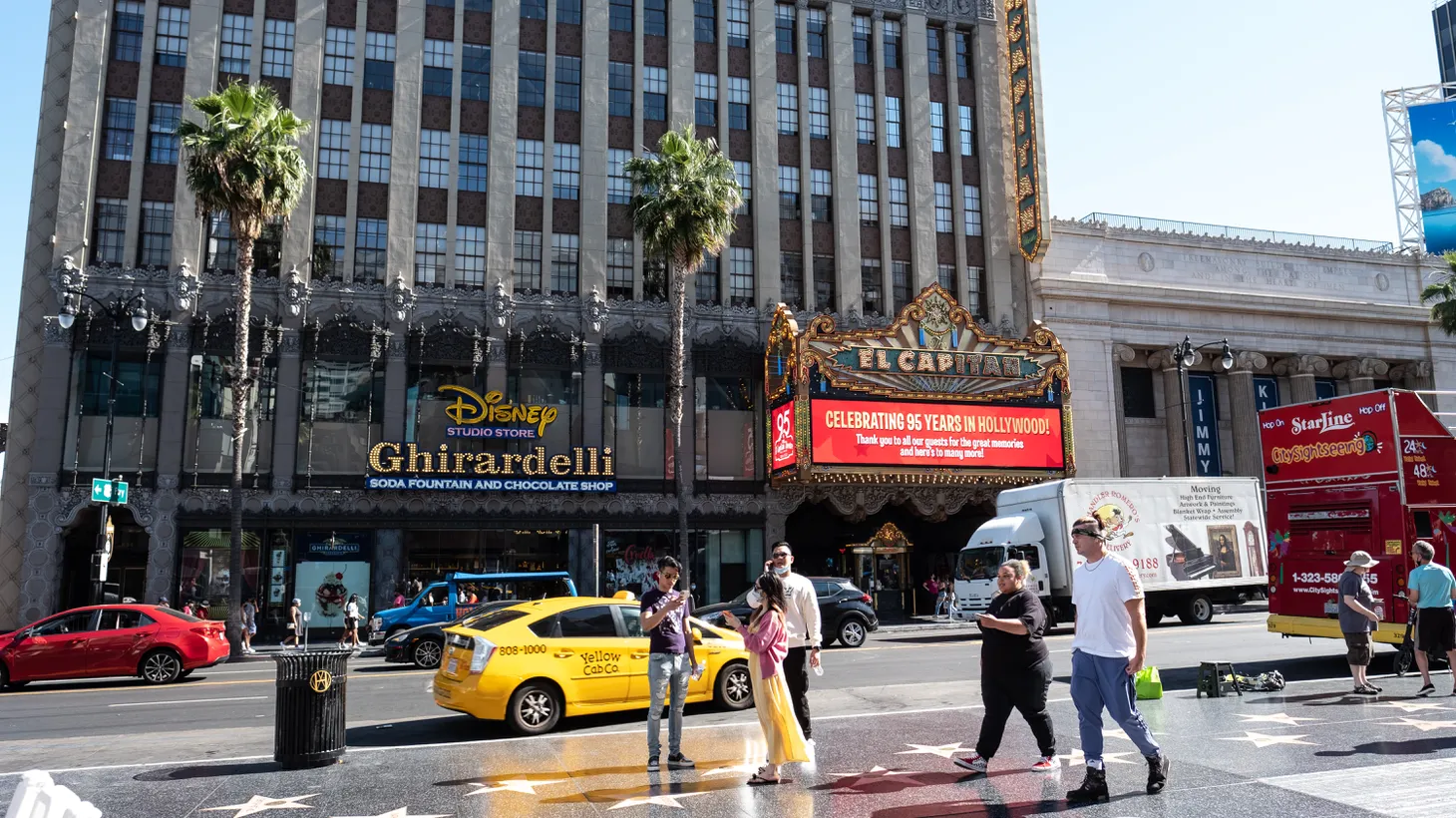 People stroll along the Hollywood Walk of Fame in front of the El Capitan Theatre in Hollywood, California.