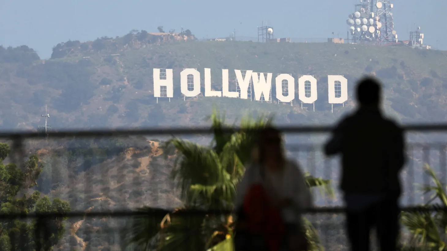 People look at the Hollywood sign the day after the Writers Guild of America (WGA) announced it reached a preliminary labor agreement with major studios in Los Angeles, California, U.S., September 25, 2023.