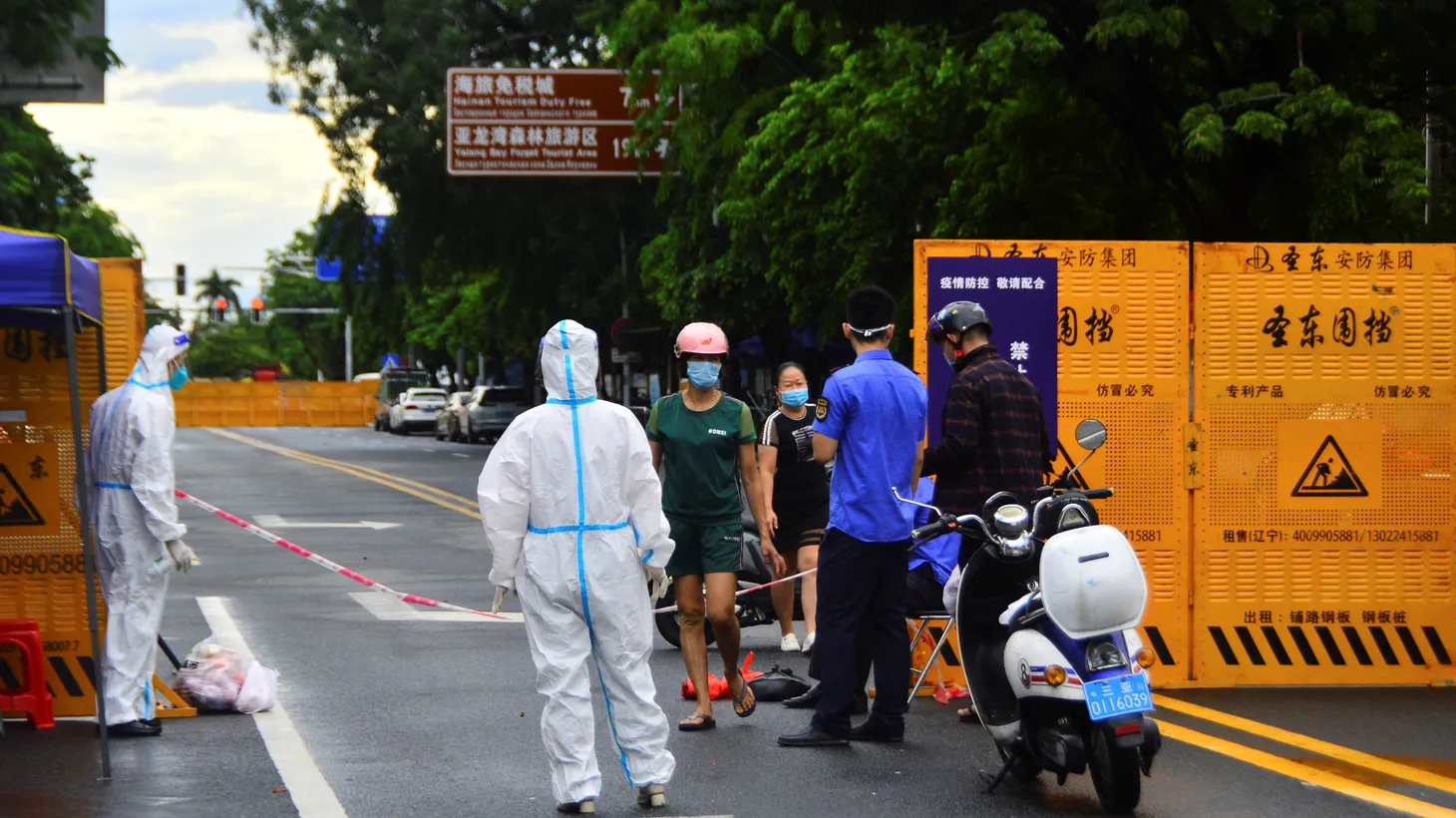 A delivery courier places food near a barricade at an entrance to a residential compound, amid lockdown measures to curb the coronavirus disease (COVID-19) outbreak in Sanya, Hainan province, China, August 8, 2022.