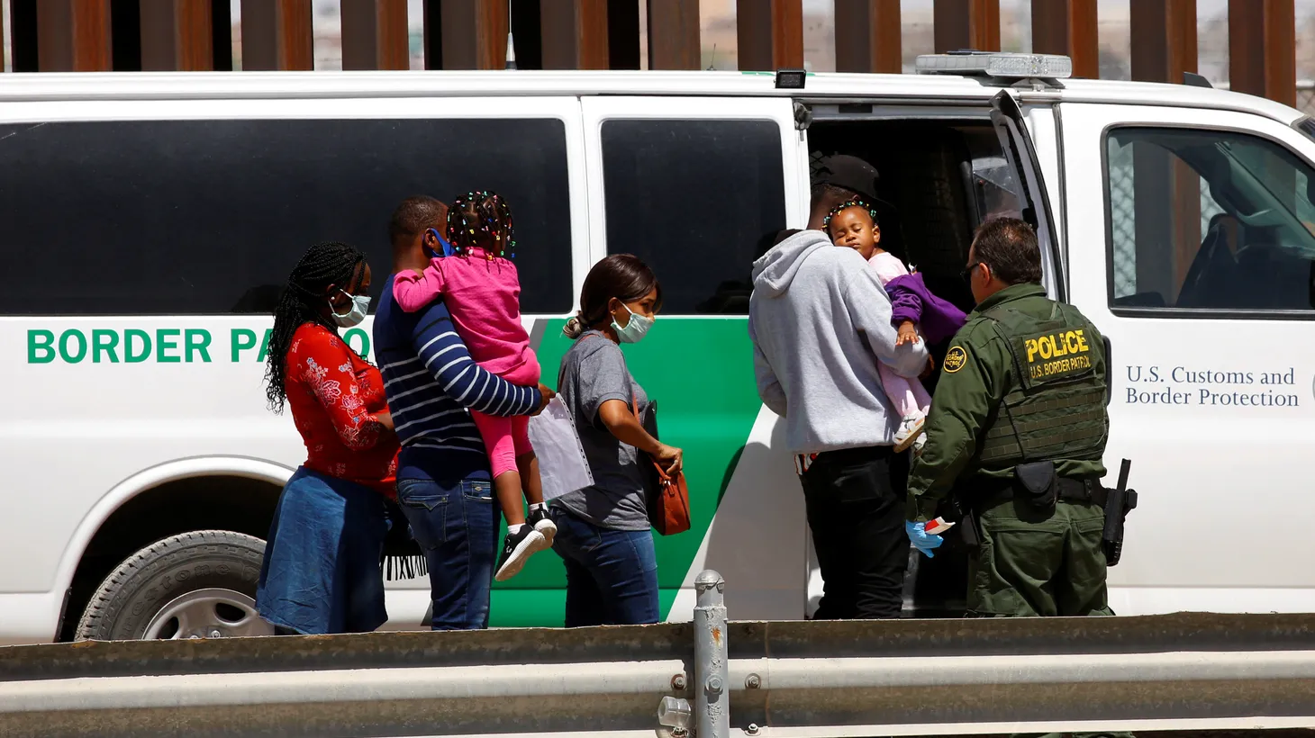 Asylum-seeking migrants are taken to a van by U.S. Border Patrol agent after they crossed the Rio Bravo river, in El Paso, Texas, U.S., as seen from Ciudad Juarez, Mexico, April 6, 2022.