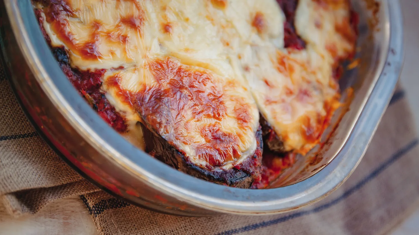 Cipolle alla parmigiana is the sweet taste of the onion with its yielding texture, layered with sauce and cheese.
