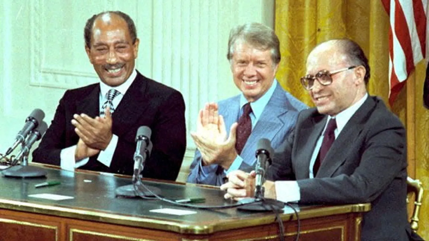 U.S. President Jimmy Carter, Egyptian President Anwar Sadat and Israeli Prime Minister Menachem Begin celebrate the signing of the Camp David Accords in the East Room of the White House in Washington, D.C., September 17, 1978.