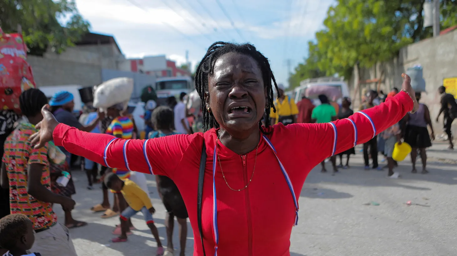 Rose Delpe cries as people displaced by gang war violence in Cite Soleil walk in Delmas after leaving Hugo Chaves square in Port-au-Prince, Haiti, November 19, 2022.