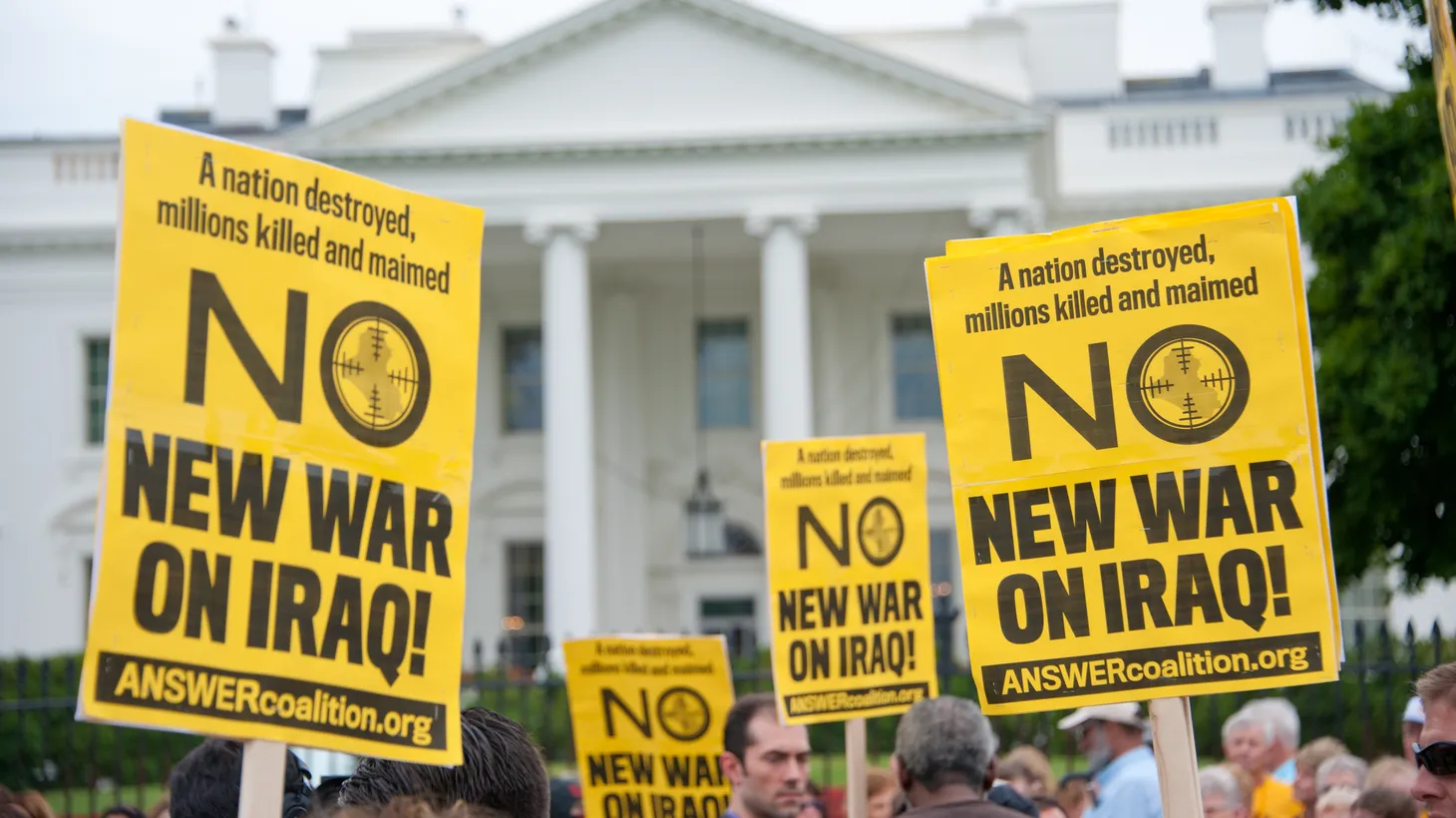Anti-war demonstrators carry signs that say “no new war on Iraq!” in front of the White House in Washington, D.C. on June 21, 2014.