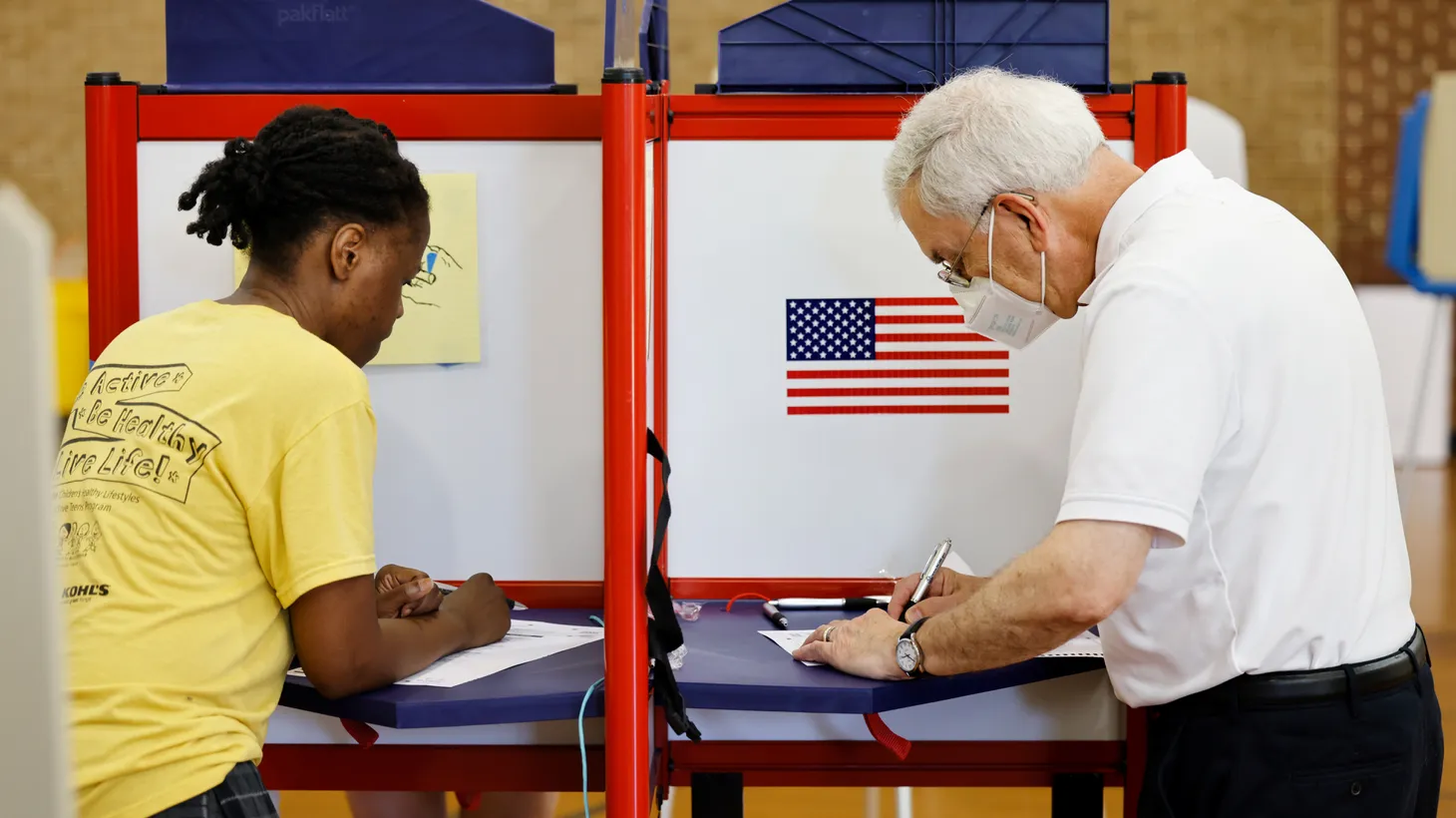 A woman and a man mark their ballots at a voting site during primary elections in Chapel Hill, North Carolina, U.S., May 17, 2022.