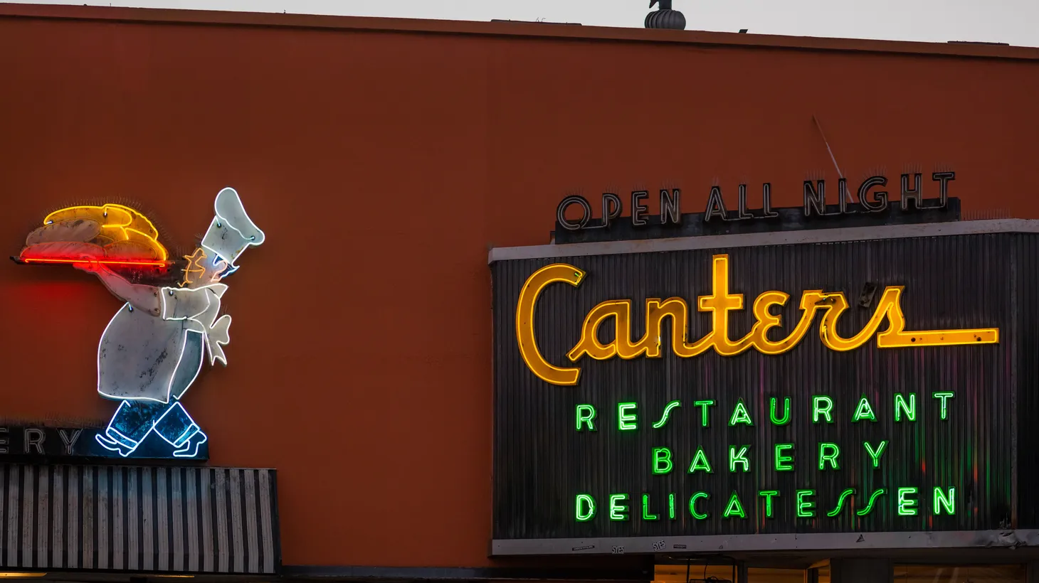 The entrance of Canter’s Deli, built in 1931, features a big neon sign advertising that the restaurant is open all night.