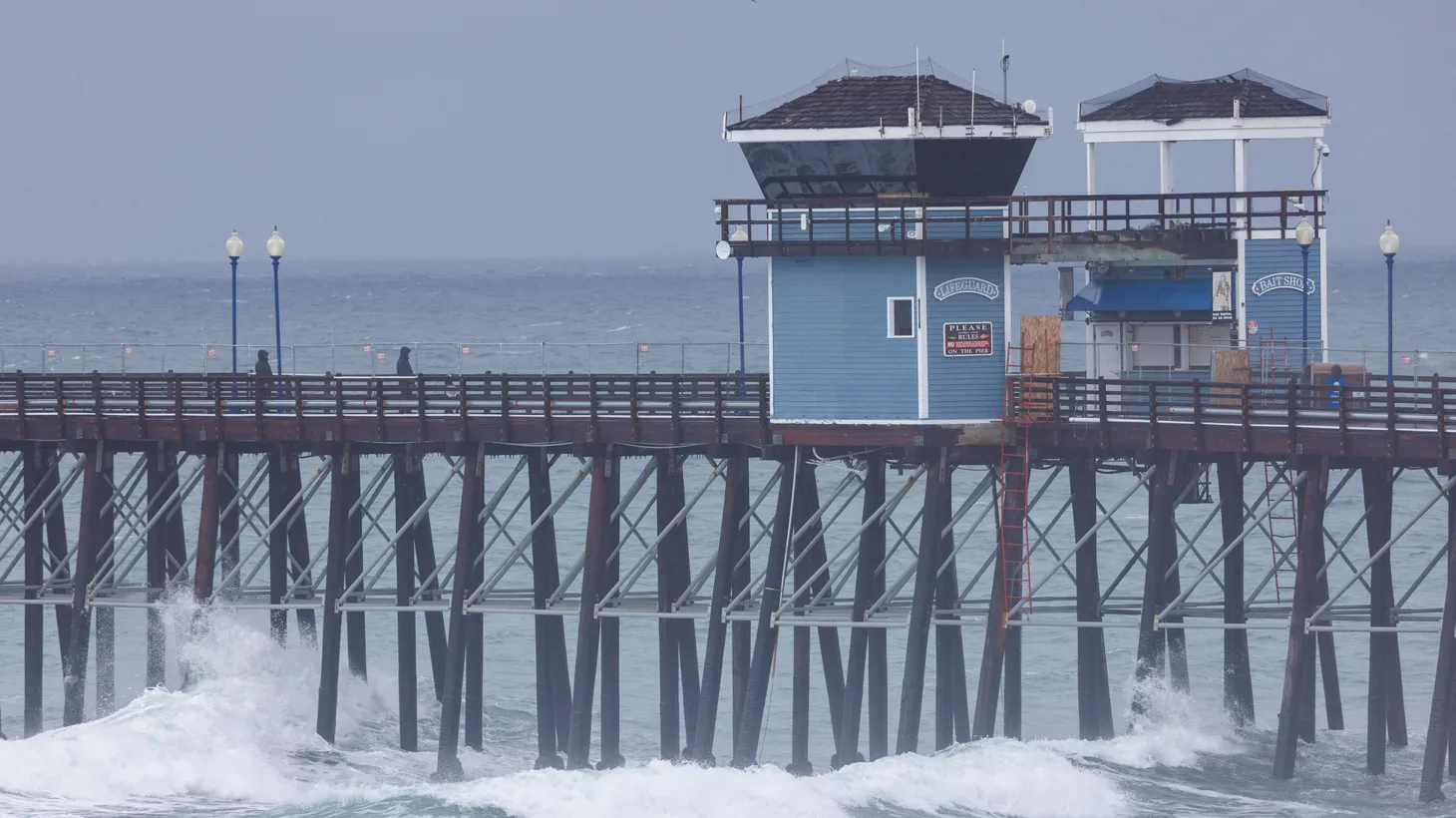 People walk along the pier during a winter storm in Oceanside, California, U.S., January 10, 2023.