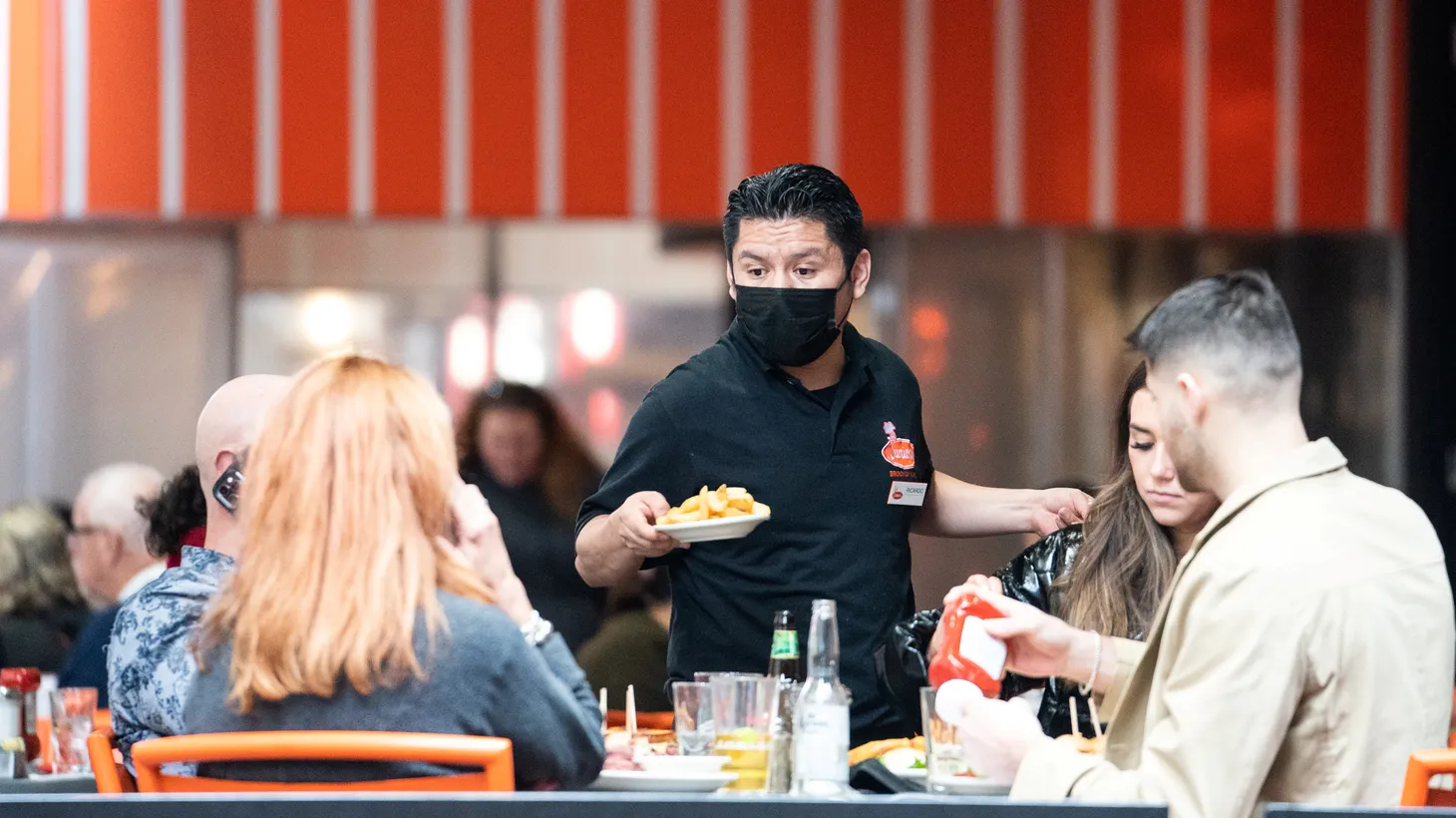 A waiter serves food at a restaurant near Times Square in New York City, U.S., December 16, 2021. “If I go to a restaurant and I eat and drink, what is it that we would think that a virus would take a vacation while you're eating and drinking?” says Dr. Michael Osterholm.