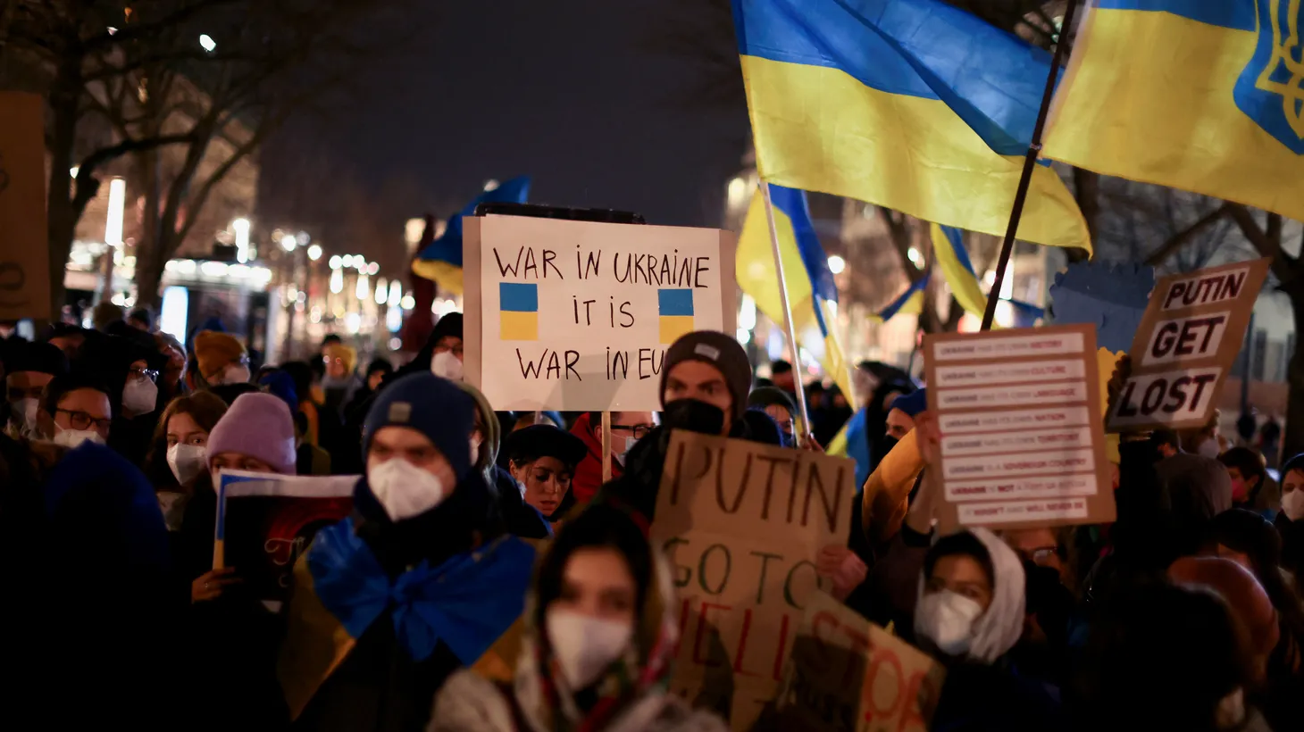 Demonstrators hold placards and wave Ukrainian flags during an anti-war protest in front of the Russian embassy in Berlin, Germany, February 22, 2022.