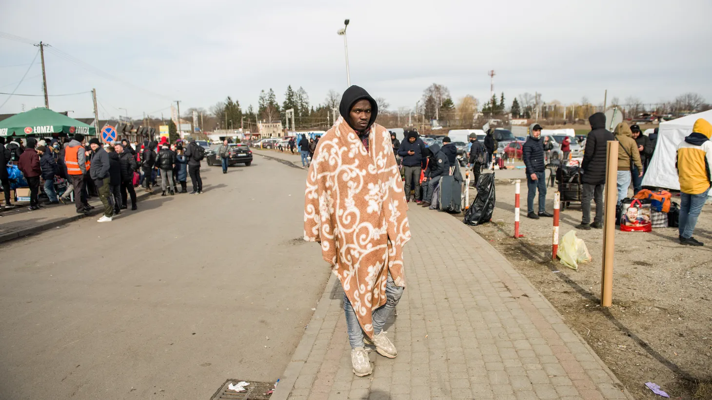 An African man covering himself in a blanket is seen at the border of Ukraine and Poland. In southeastern Poland, hundreds of non-Ukrainians are sheltering. People fleeing the war in Ukraine for the safety of European border towns include citizens of African, Asian and Middle East countries.