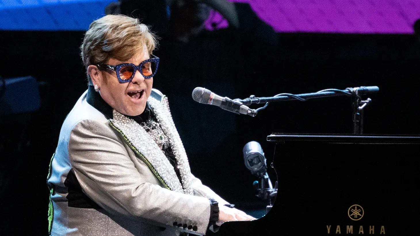 Singer and pianist Elton John sits onstage at the Olympiahalle during a concert as part of his "Farewell Yellow Brick Road Tour 2023."