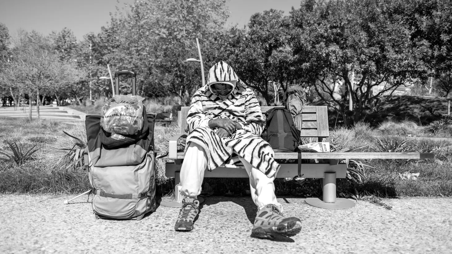 An unhoused man sits with his belongings on a bench at Tongva Park in Santa Monica, February 25, 2022. “Lead Me Home” is a new Oscar-nominated short documentary about several people living on the streets, including in Los Angeles County.